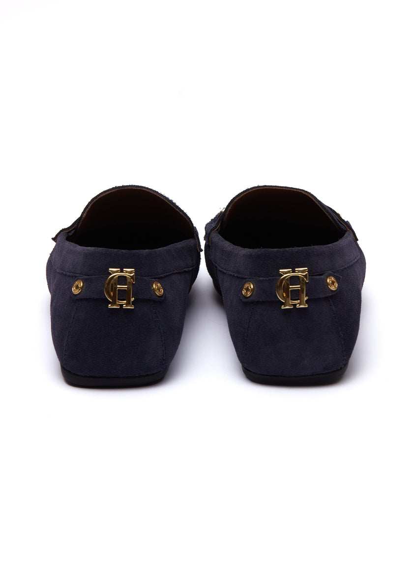 back of navy suede loafers with a leather sole and gold hardware