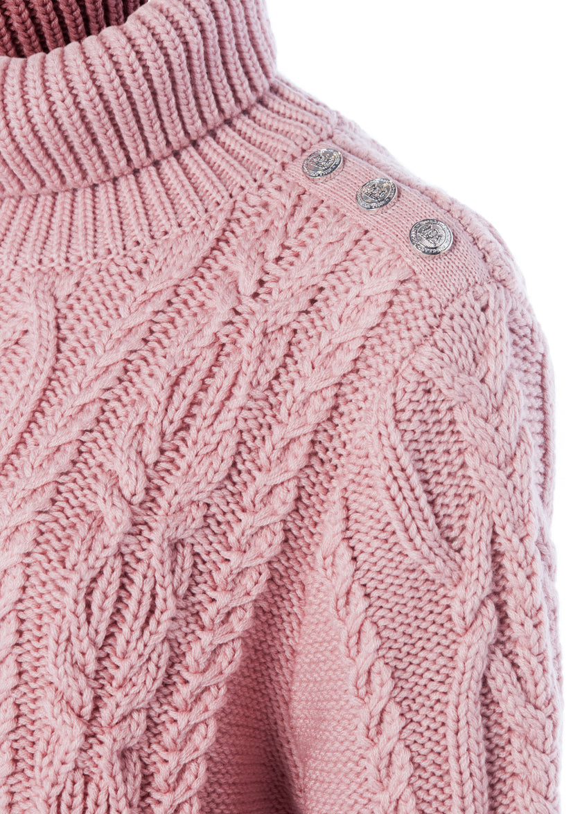 silver button detail across cuffs of chunky cable knit jumper in blush pink with ribbed roll neck hem and cuffs